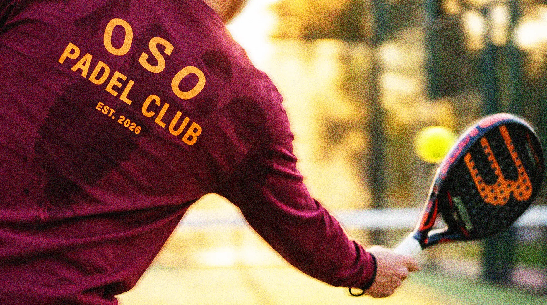 Padel player in burgundy OSO clubwear on court